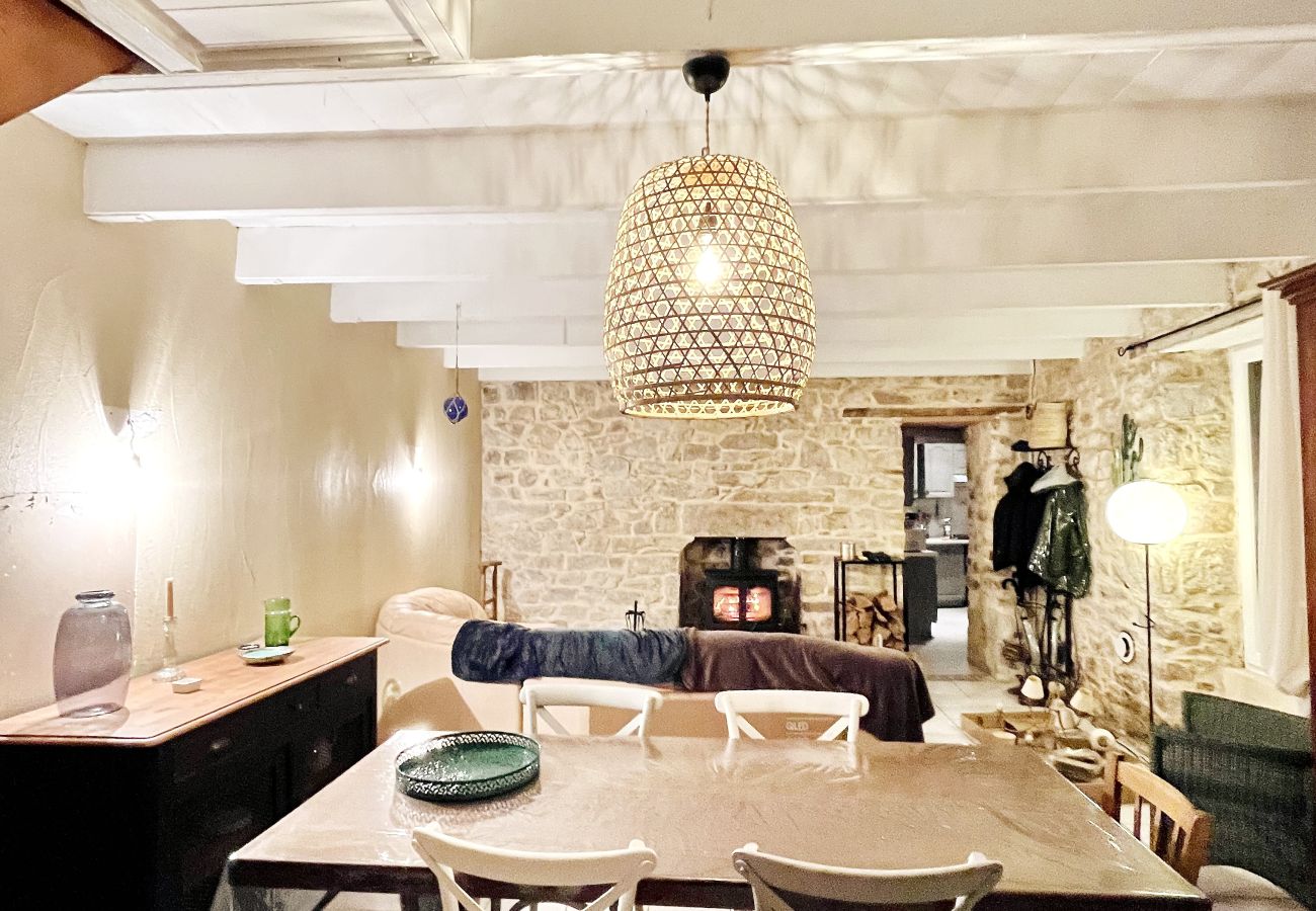 Salle à manger et salon TV avec poêle à bois, accès direct à la terrasse.